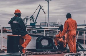 a group of men in orange jumpsuits sitting on a boat